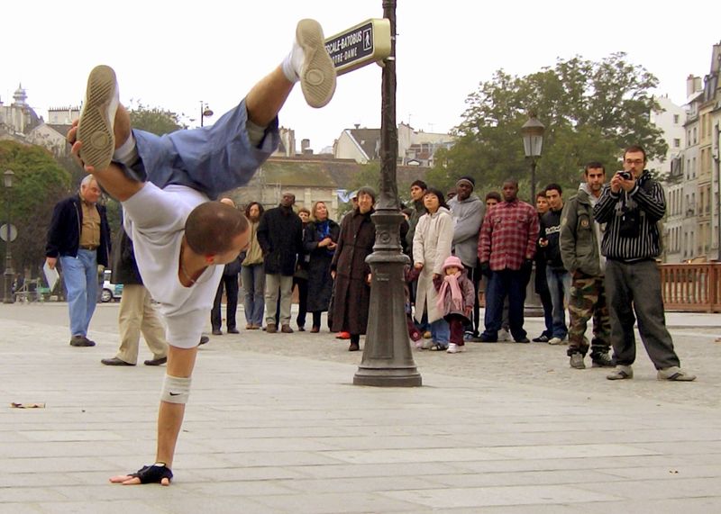 A street performer doing the Freeze(a.k.a. Pike) in the streets of Paris